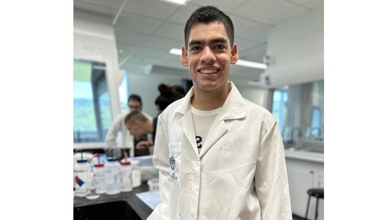 College student wearing lab coat in college laboratory.